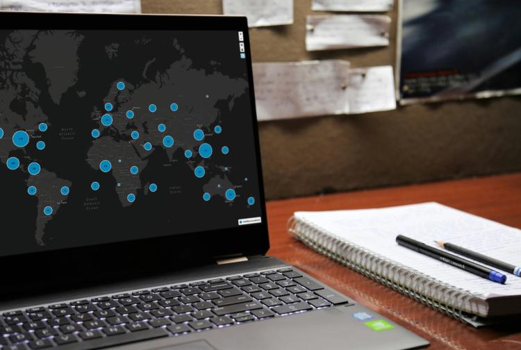 A laptop showing various blue colored points on a world map