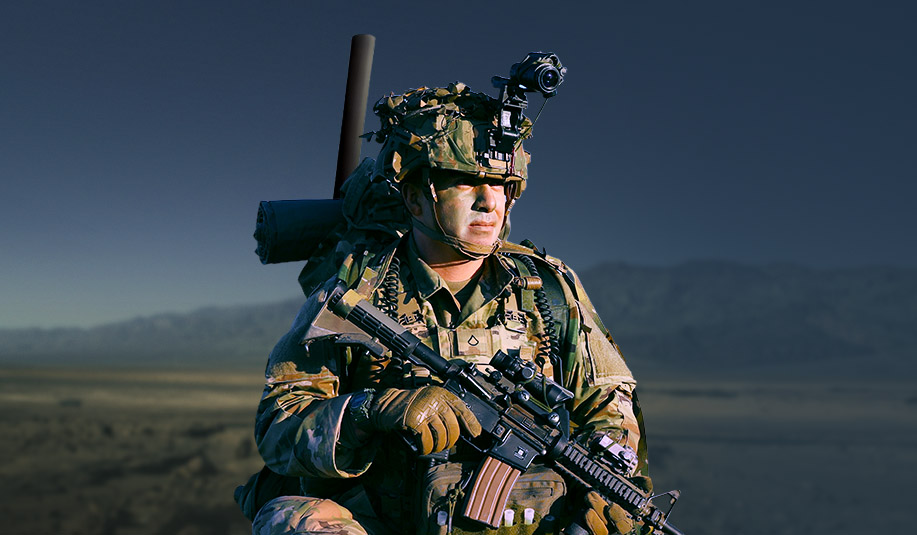 Soldier in field looking towards horizon