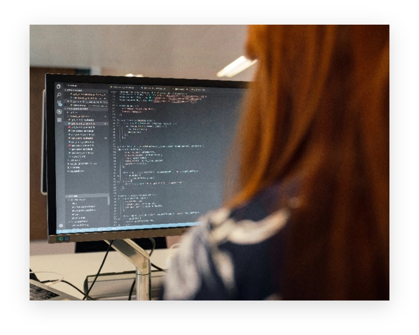 A person looking at code on a monitor.