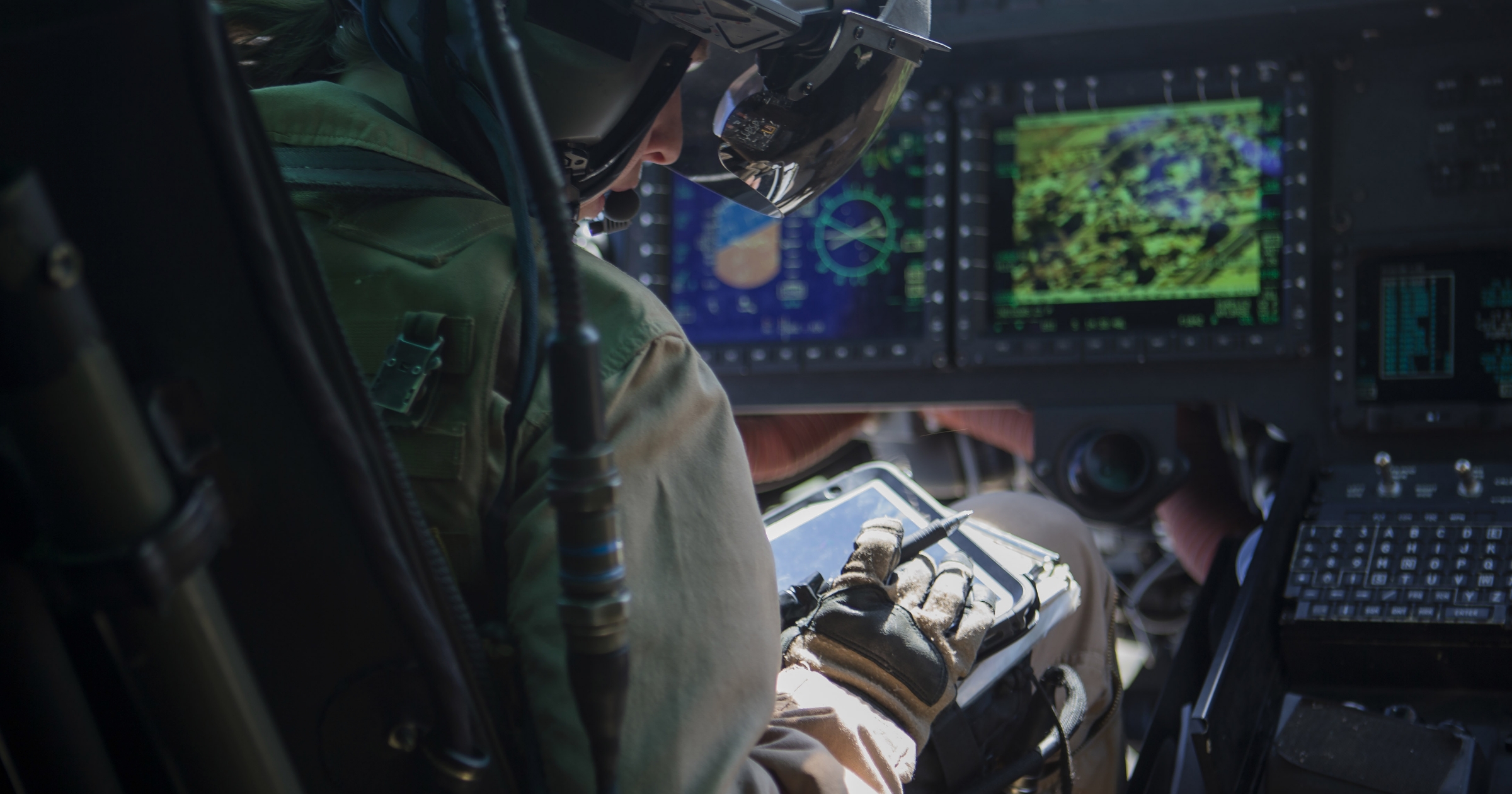 A soldier in a helicopter on a tablet