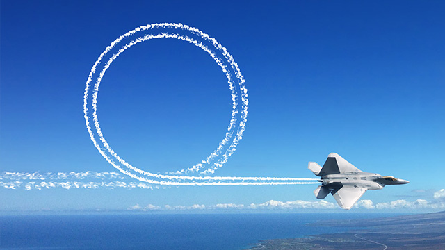 A fighter jet performs an aerial maneuver over a vast ocean.