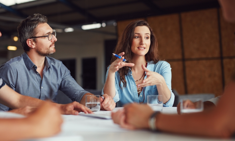 A woman focused on her computer while working in a modern office environment.
