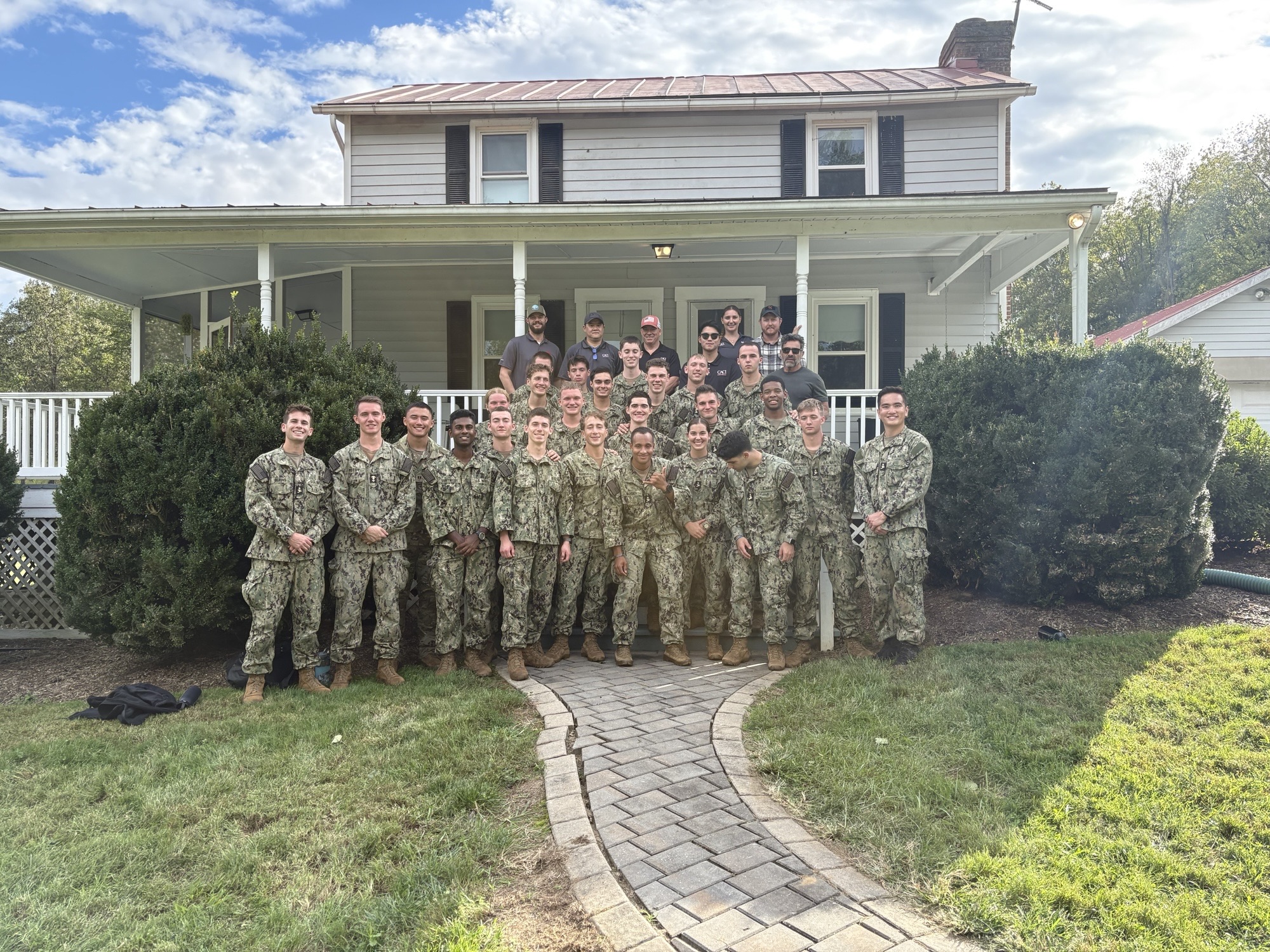 CACI team members and ARES midshipmen gather for a group photo outside the Farm facility.