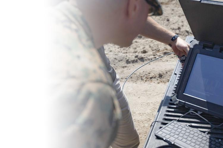 soldier looking at computer in field