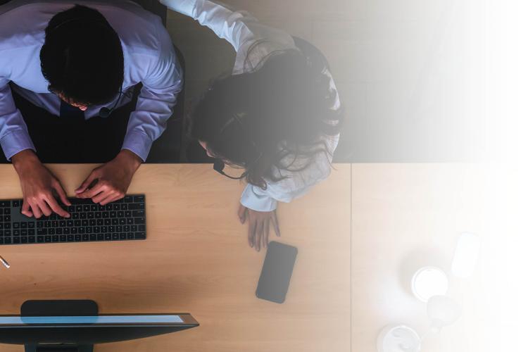 A team of individuals focused on a computer screen, exchanging thoughts and working together on a project.