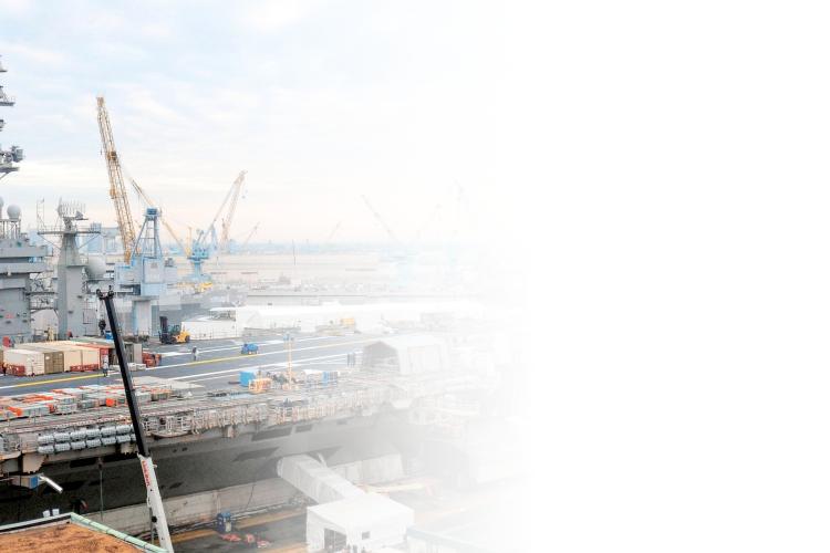 A large ship equipped with cranes and construction equipment, docked and ready for loading or unloading operations.