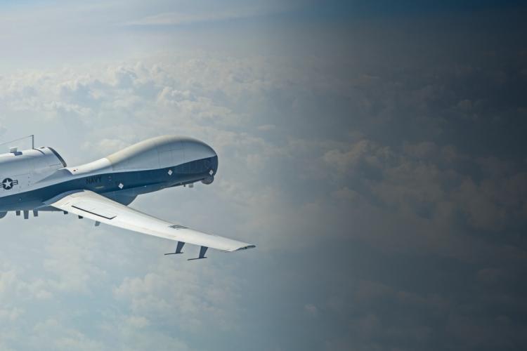 A white and blue drone soaring through a clear blue sky, showcasing its sleek design and aerial capabilities.