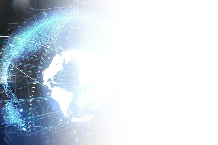 A woman wearing glasses gazes at a screen displaying a globe, indicating a focus on global information or geography.