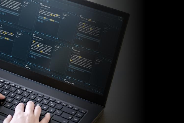 A person focused on typing on a laptop computer, with hands positioned over the keyboard and a screen visible.