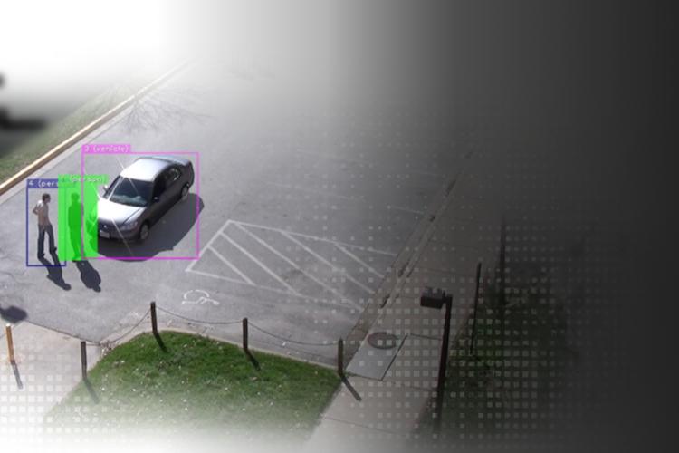 A car drives down the road, featuring a prominent green dot on its side.