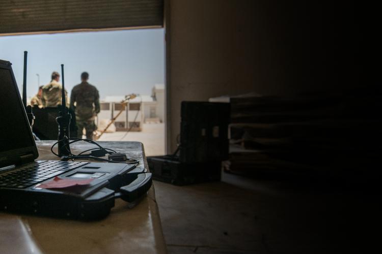 A laptop on a table beside a camera, showcasing a workspace setup for photography or video editing.
