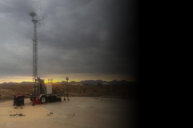 A tall radio tower, silhouetted against a vibrant sunset sky.