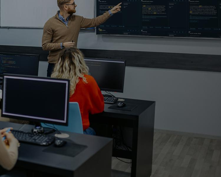 A group of people gathered around a computer screen, engaged in discussion or collaboration.