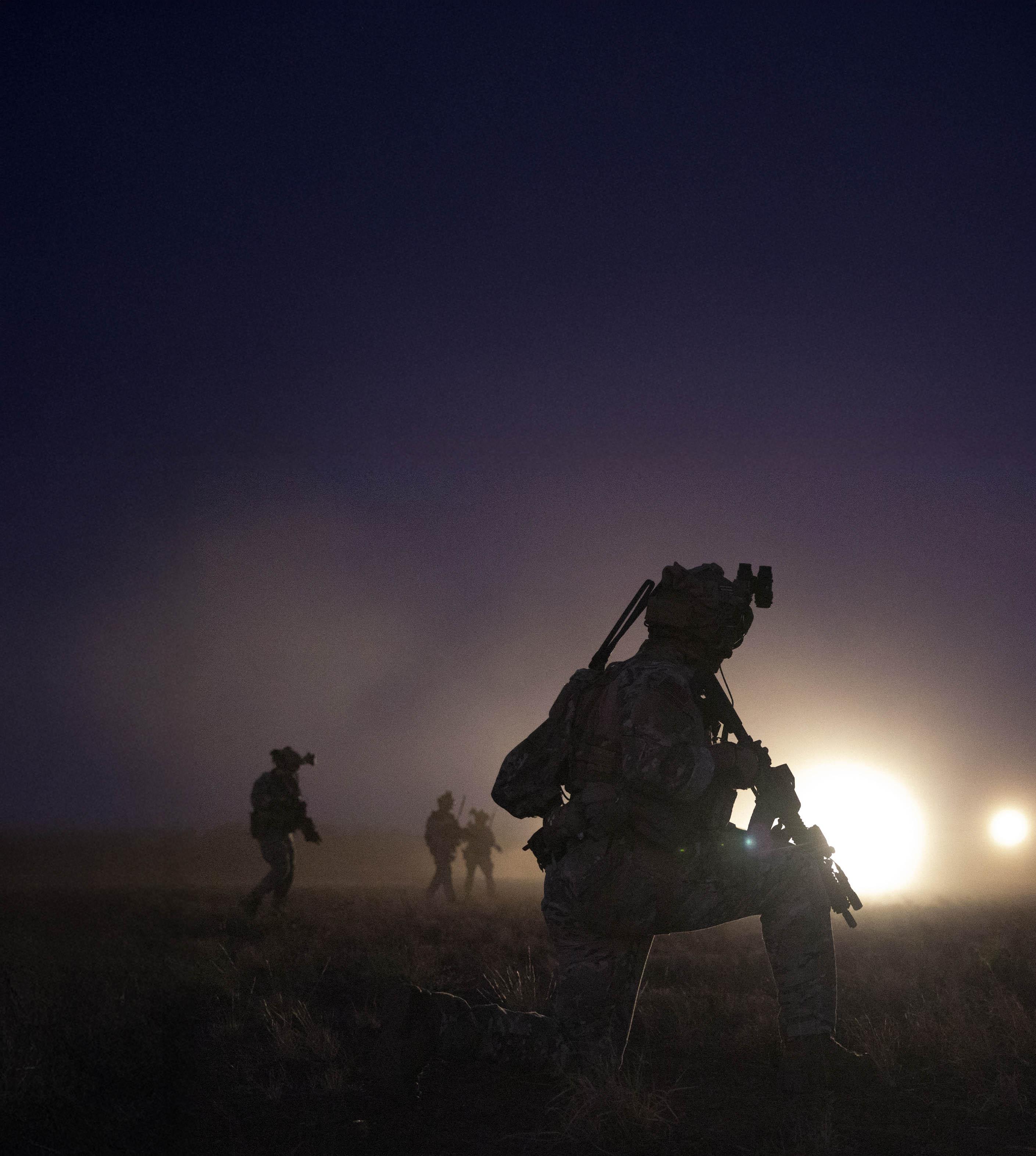 A soldier walks through darkness.