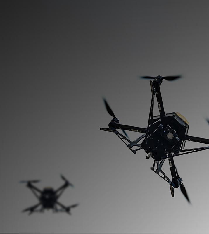 A black and white image featuring two small drones positioned side by side against a neutral background.