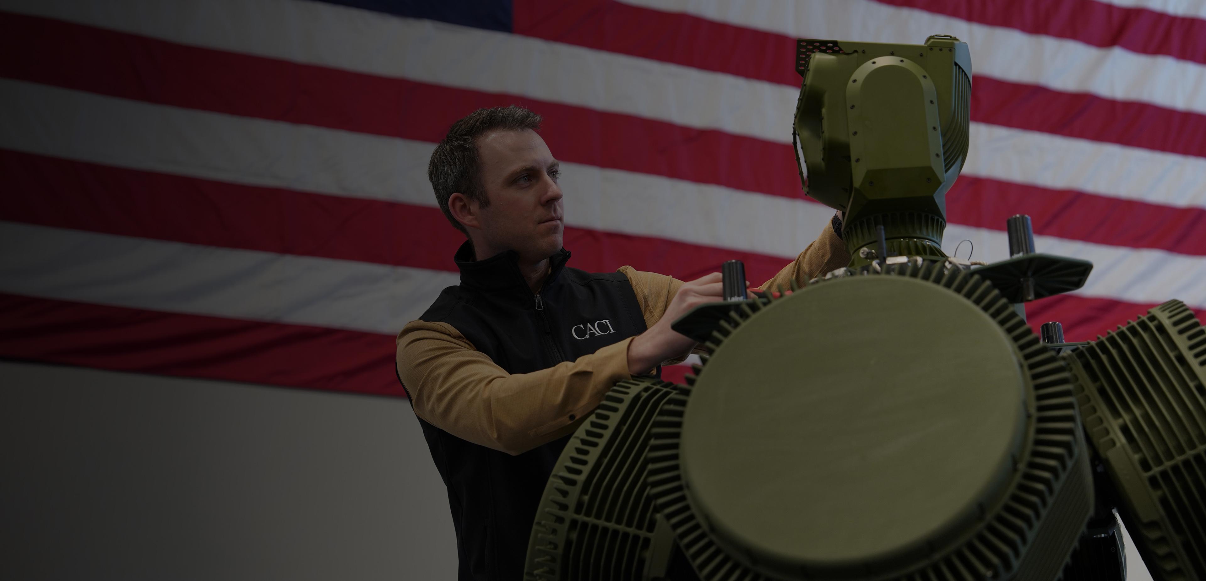 A man is assembling a large green robot, focused on its intricate mechanical components.