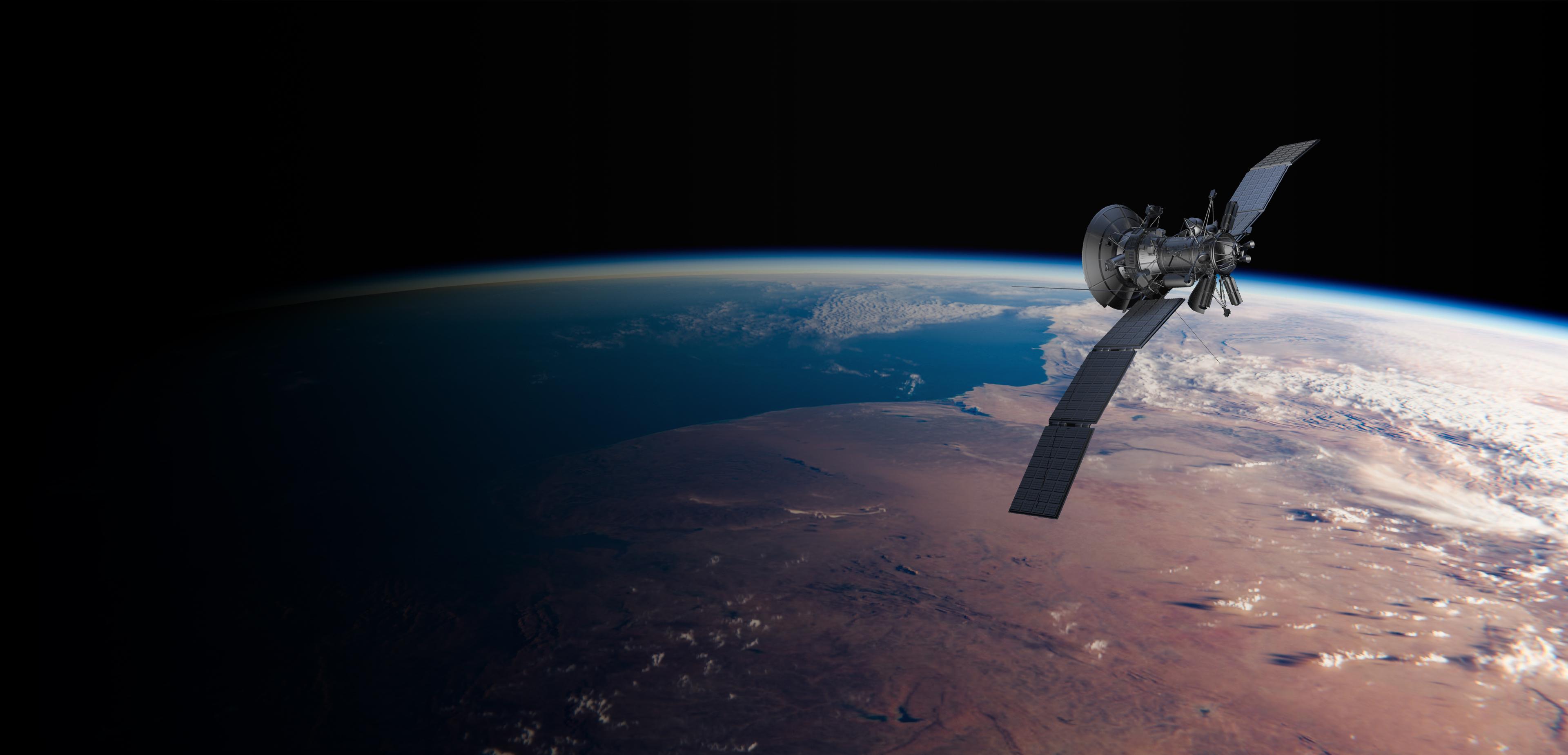 Satellite with extended solar panels orbits above Earth’s curved horizon, revealing blue atmosphere, clouds, and vast desert landscapes in space.