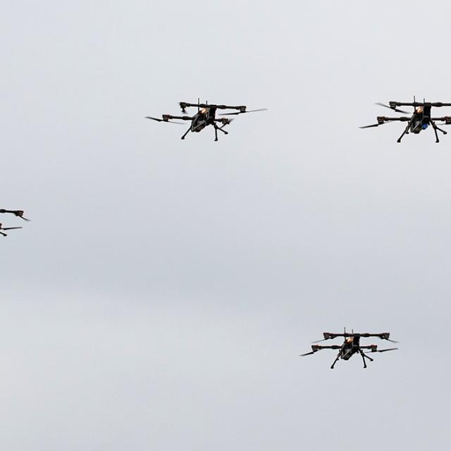 Four drones flying in the sky during a training exercise, showcasing advanced technology and precision aerial maneuvers.