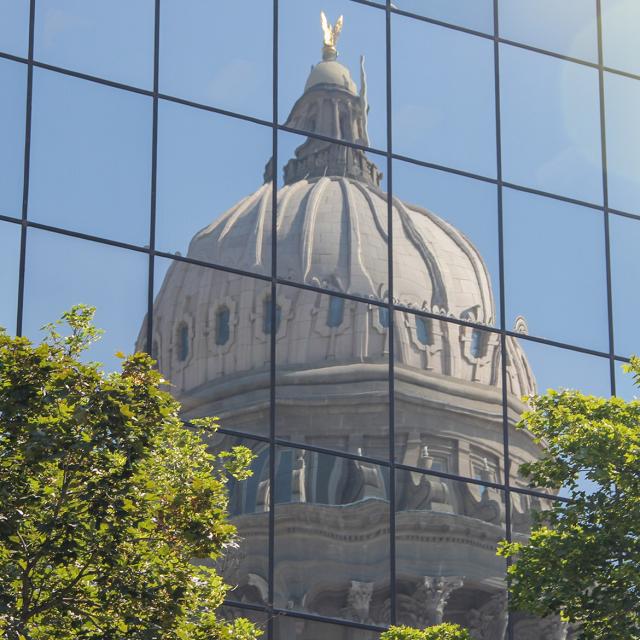 The US Capital reflected on a buildings exterior windows.