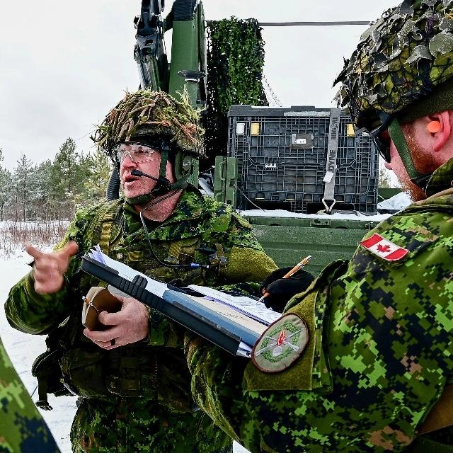 Soldiers navigating through deep snow, showcasing their resilience and determination in a winter landscape.