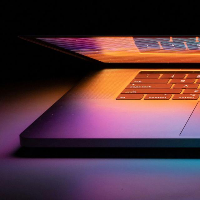 a macbook under orange and purple gradient lighting.