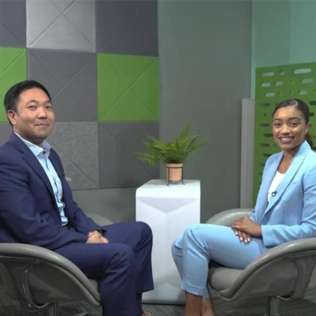 Two people seated in chairs engaged in a conversation, appearing focused and attentive to each other.