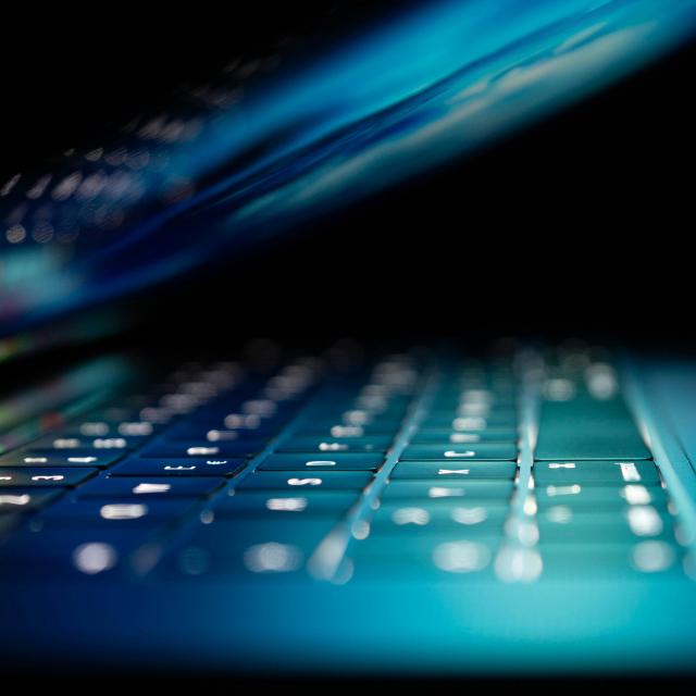 A half closed laptop with a lightup keyboard