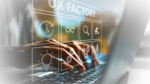 man at computer with UX Factory in foreground