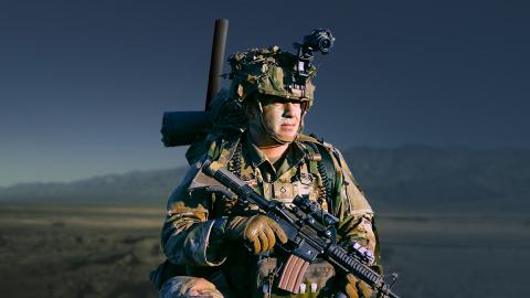 Soldier in field looking towards horizon
