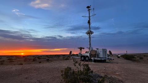 CACI's SkyValor stands prominently in the center of a vast desert landscape under a clear blue sky.