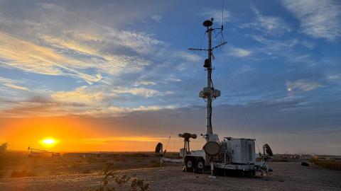 CACI's SkyValor stands on a hill, silhouetted against a vibrant sunset sky.