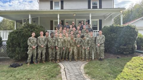 CACI team members and ARES midshipmen gather for a group photo outside the Farm facility.