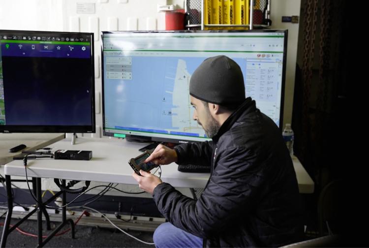 A man focused on two monitors.