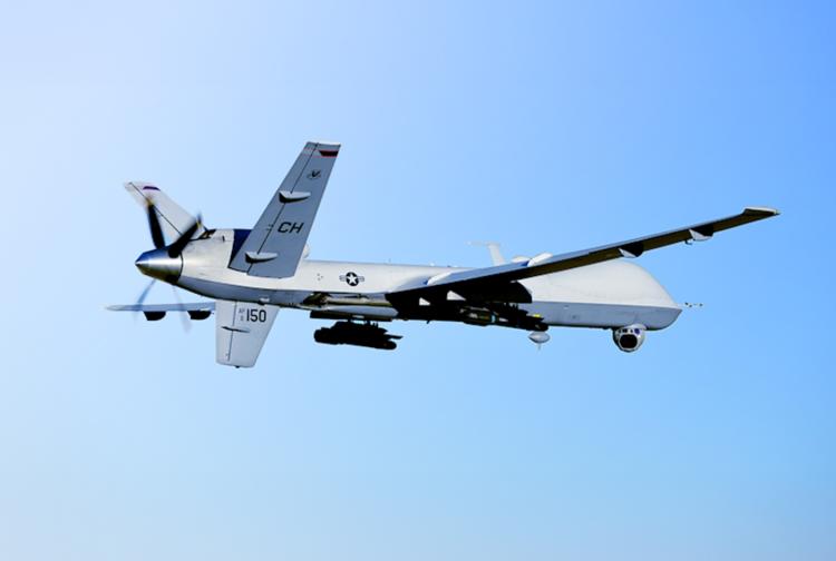 A military drone soaring through a clear blue sky, showcasing its sleek design and advanced technology.