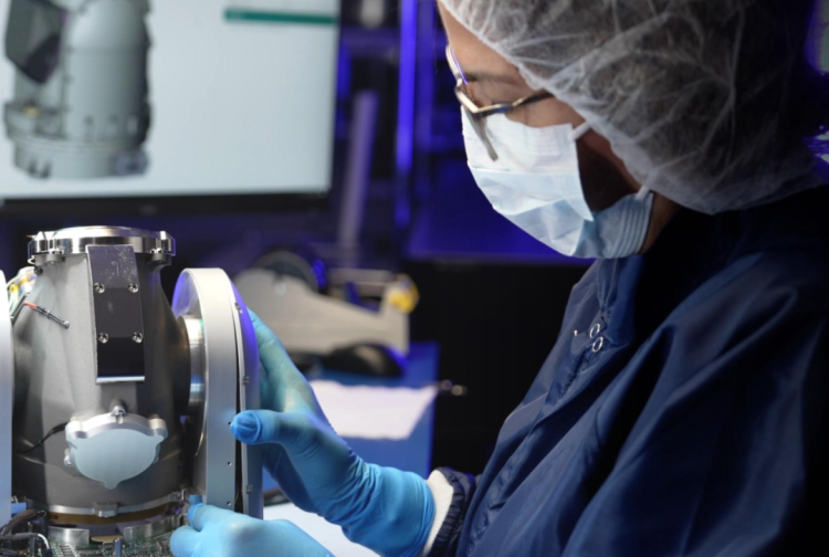 A person wearing a mask working in a lab.